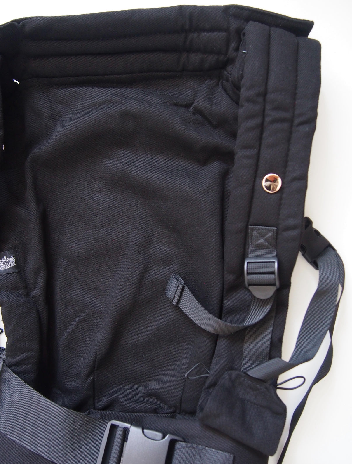 Black ergonomic baby carrier back view - soft-structured carrier with adjustable straps