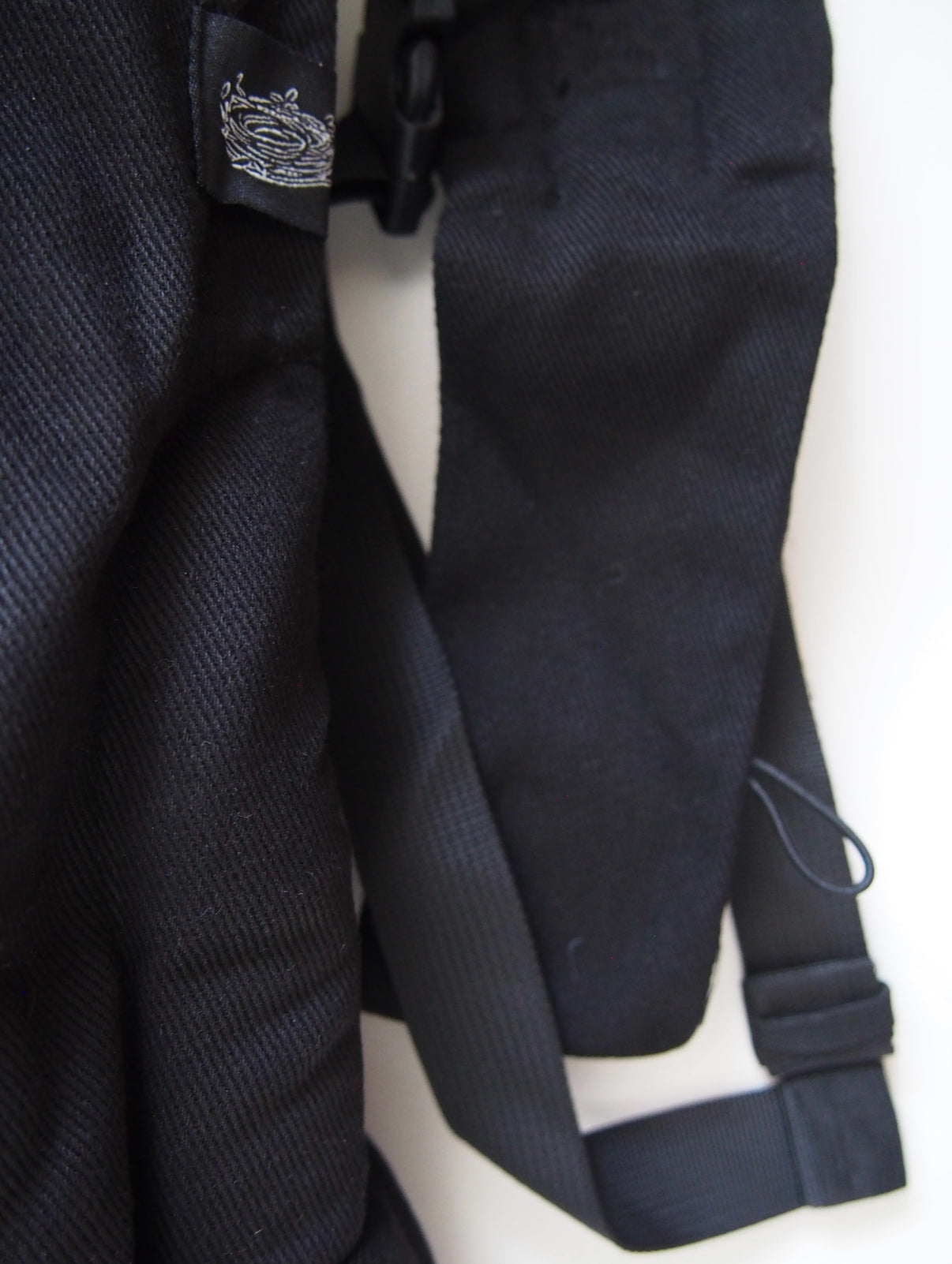 Black ergonomic baby carrier back view - soft-structured carrier with adjustable straps