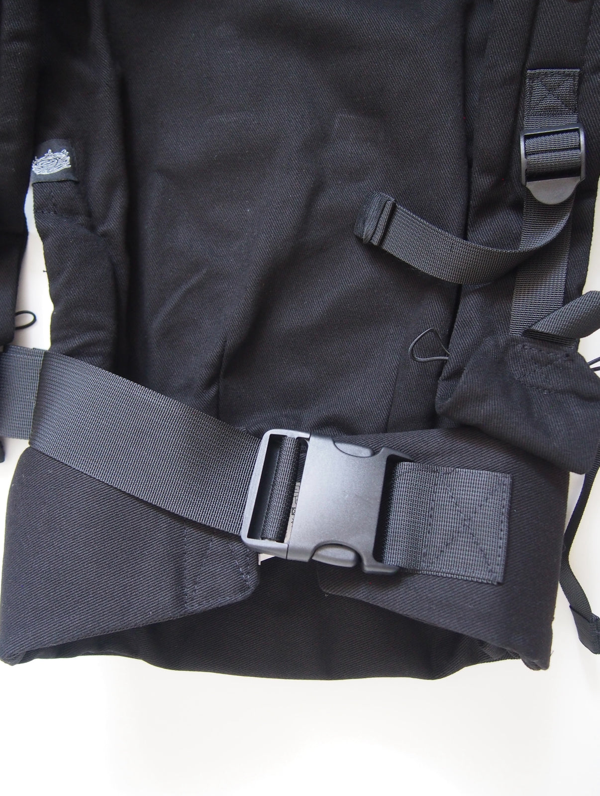 Black ergonomic baby carrier back view - soft-structured carrier with adjustable straps